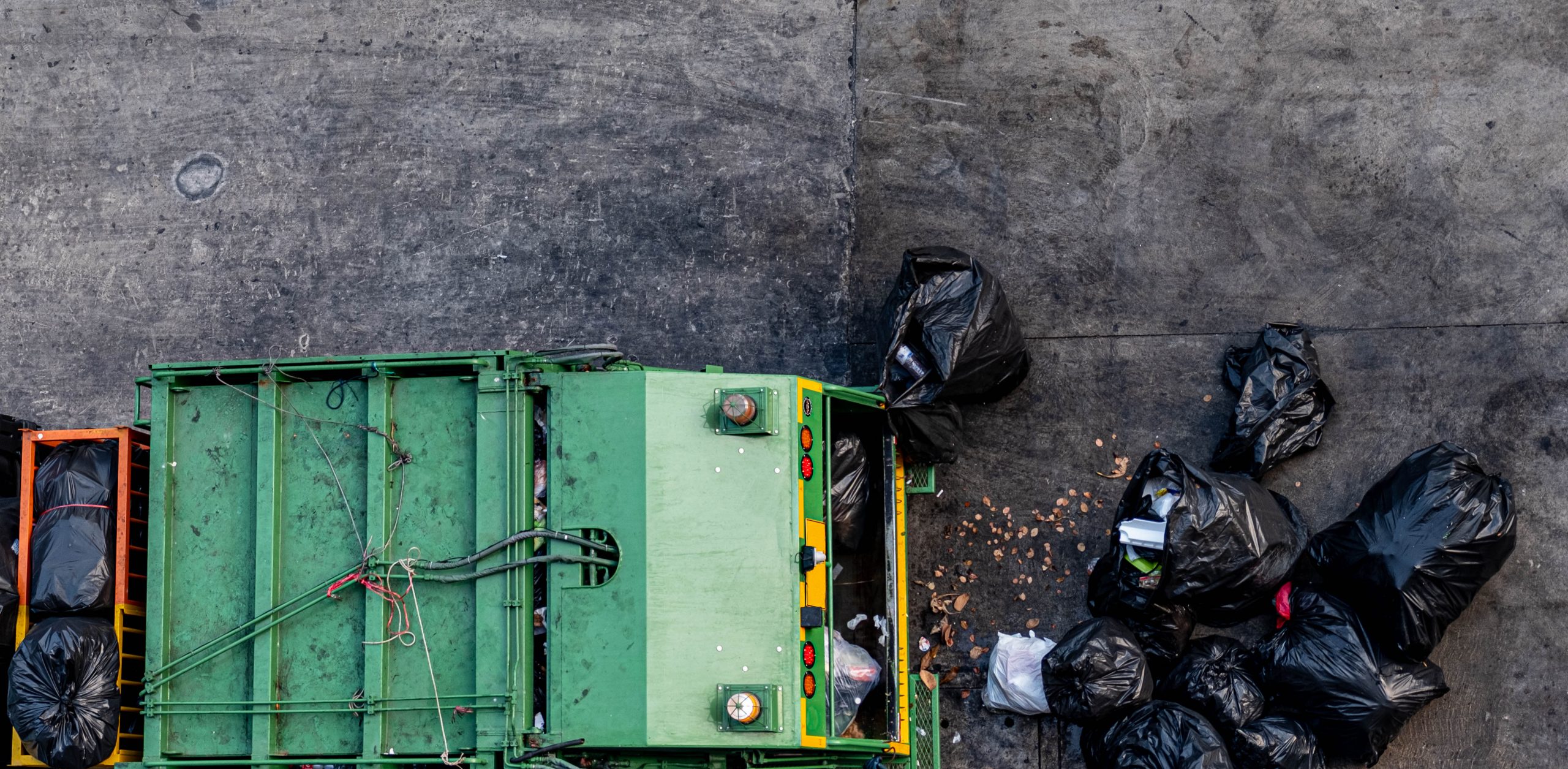 green-garbage-truck-collecting-large-number-black-garbage-bags